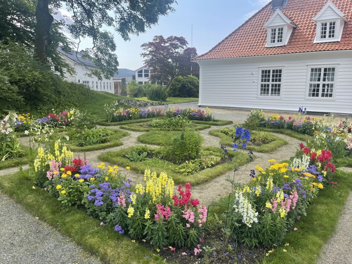 Blomsterbed foran deler av hovedbygningen på Stend vgs